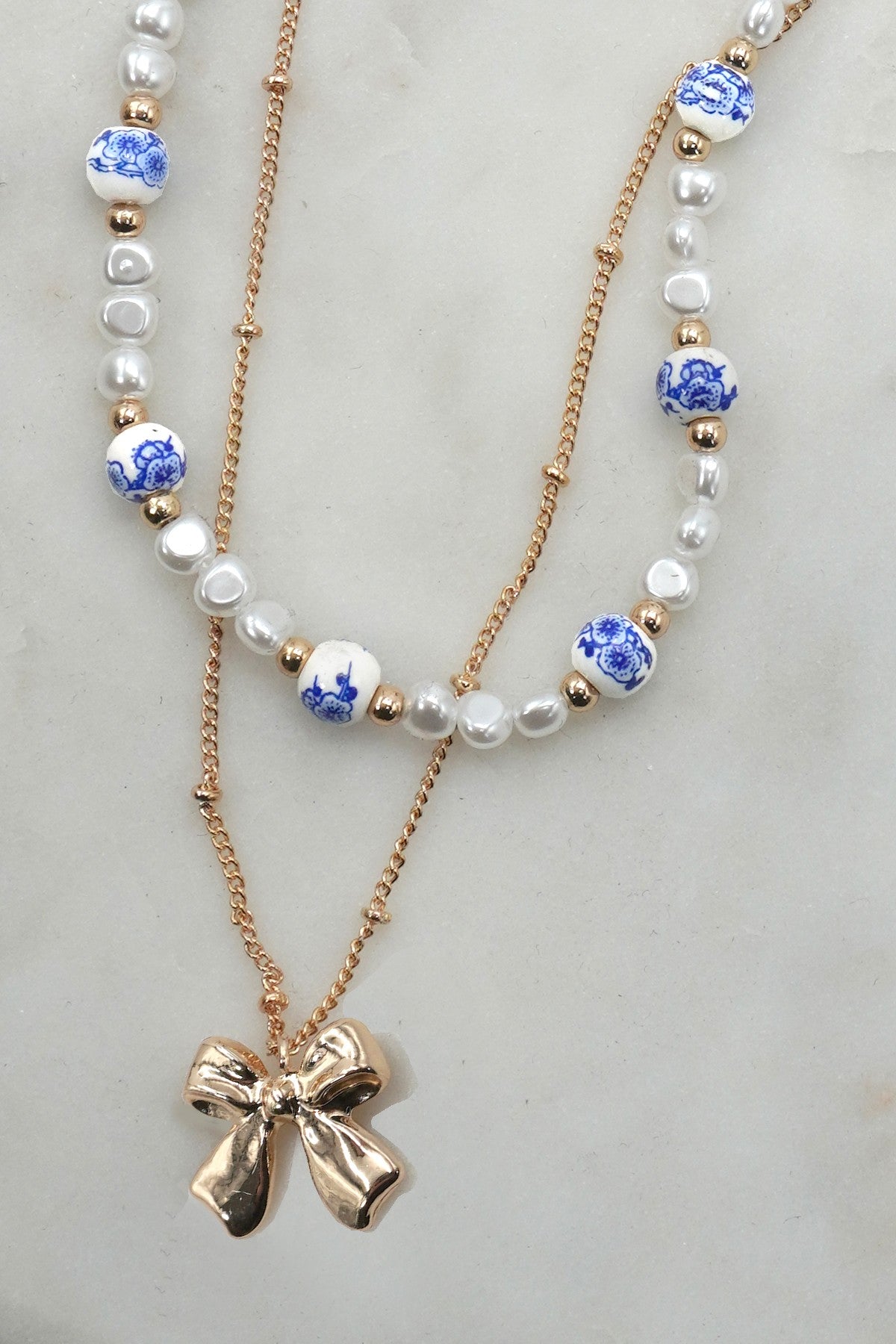 BLUE TOILE PATTERN PEARL AND BOW NECKLACE