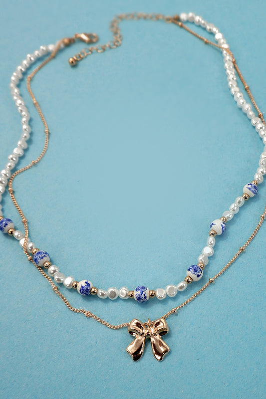 BLUE TOILE PATTERN PEARL AND BOW NECKLACE